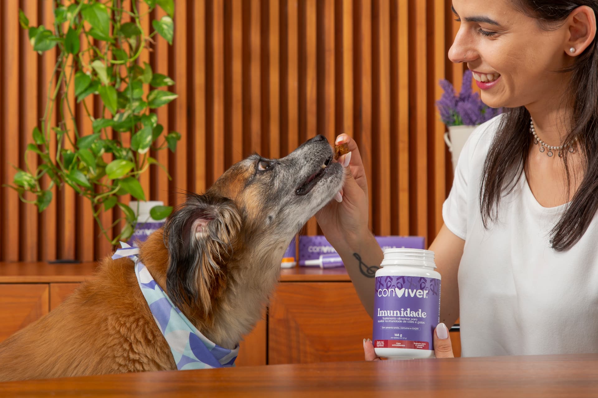 Tutora oferecendo Conviver Imunidade ao pet